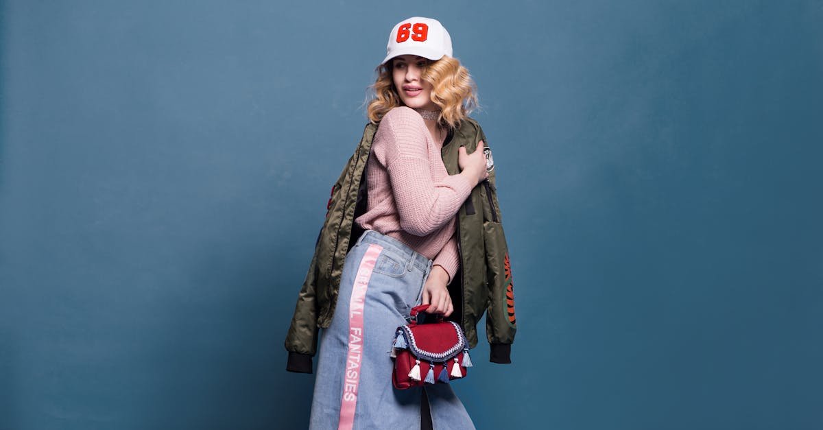 Fashion portrait of a young woman with a stylish denim outfit, cool jacket, and a vibrant cap.